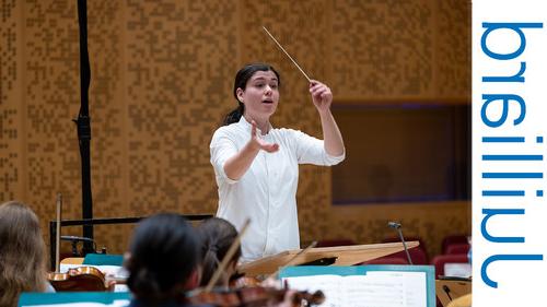 Woman conducting an orchestra rehersal